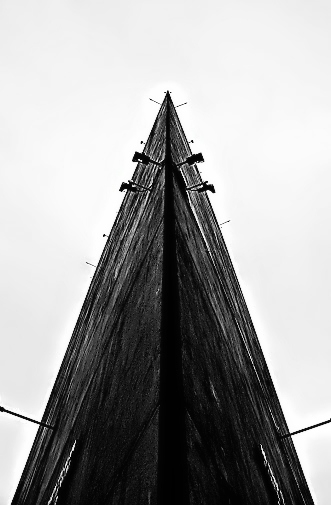 Black and white photo showing the view from under the bow of a ship, creating a symmetrical triangle in the photo.